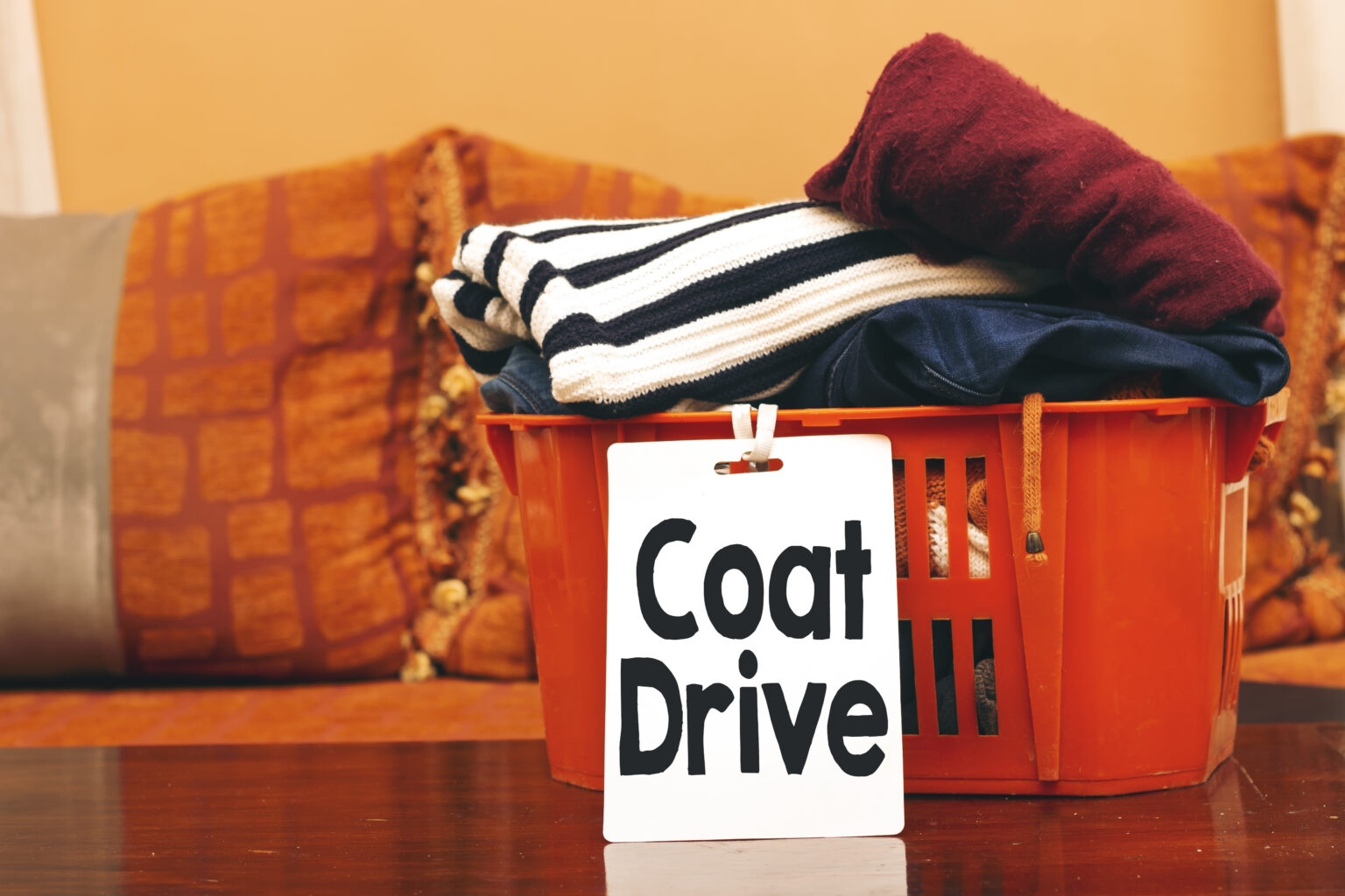 clothes in orange basket or box with coat drive card